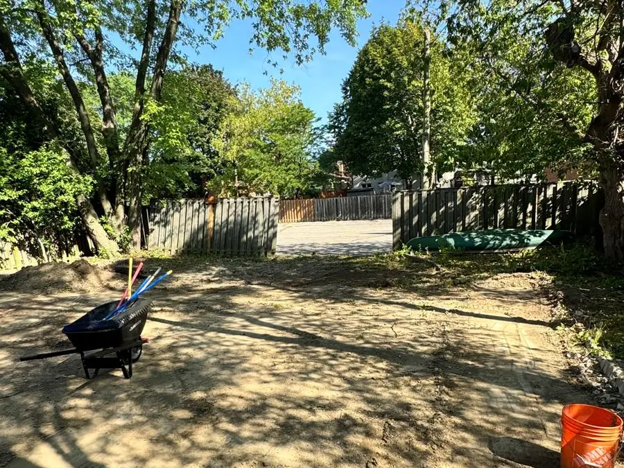 Bare dirt backyard with a wheelbarrow