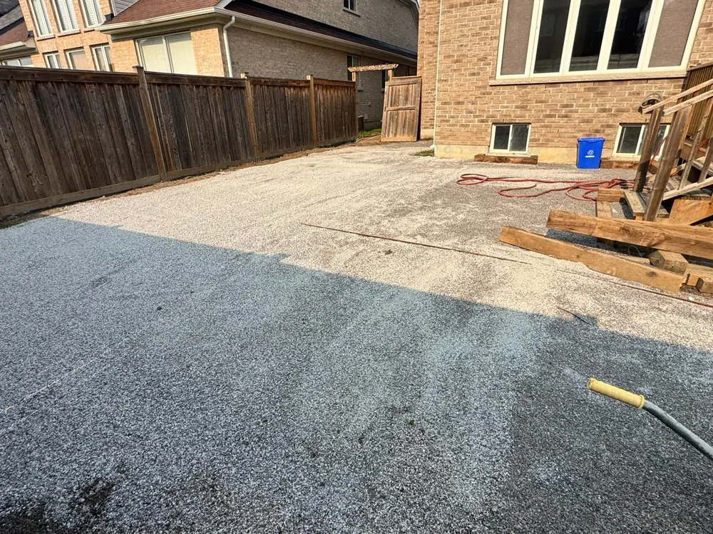 Compacted granular base across a driveway run, ready for the bedding course