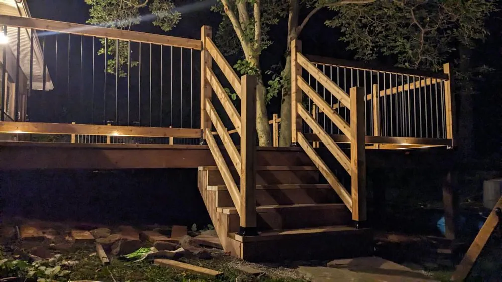 A deck and its stair run lit after dark