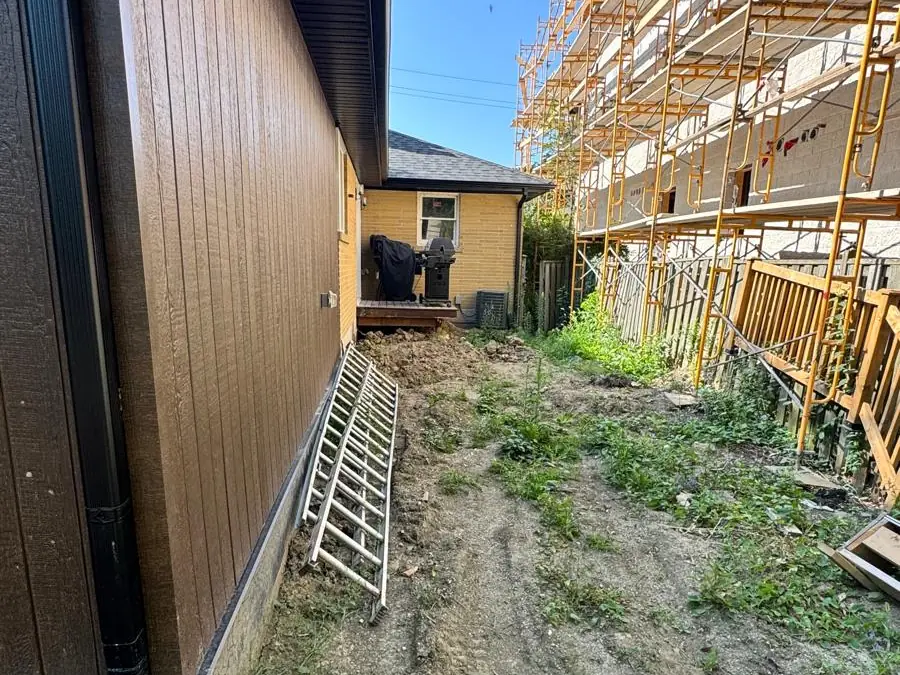 Side yard before work, scaffold against the wall