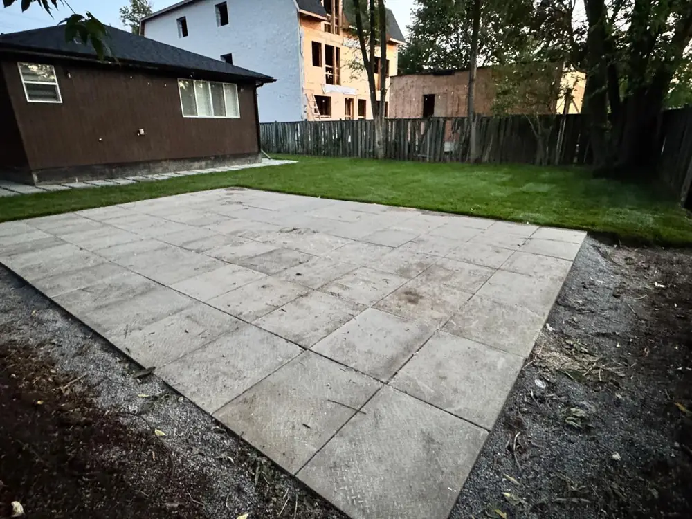 Wide slab patio bordered by newly laid sod